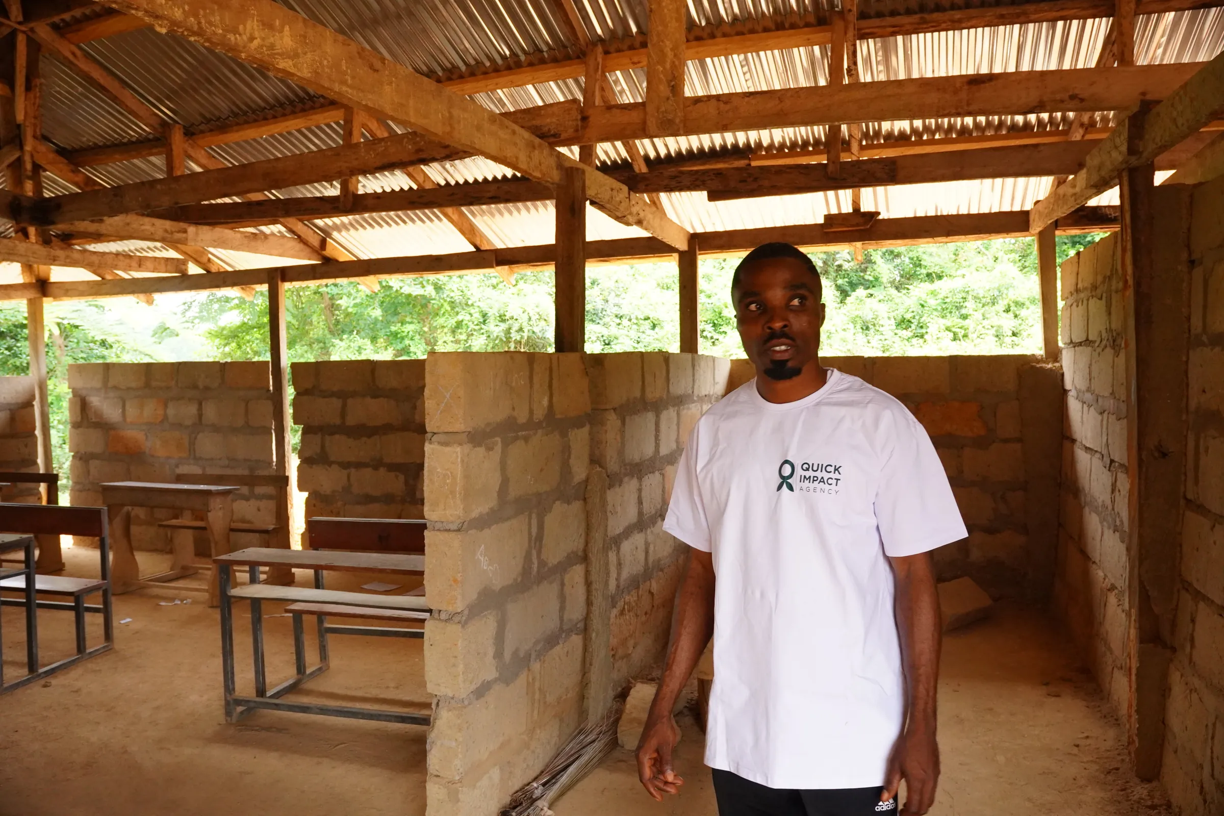 A QIA staff member standing in the blockwork building going up at the project site