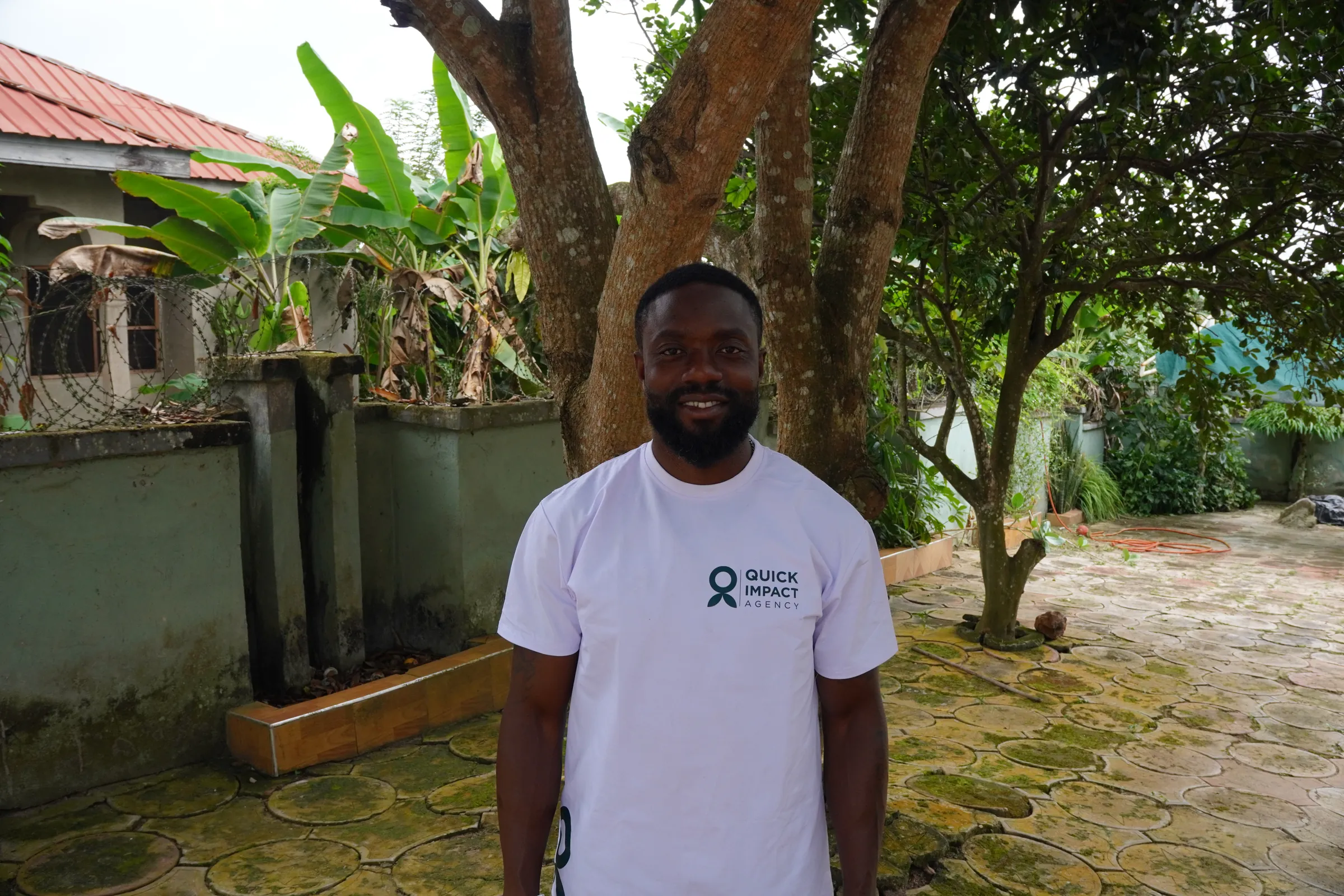 A QIA staff member in a branded shirt at the project site in Sefwi Bekwai