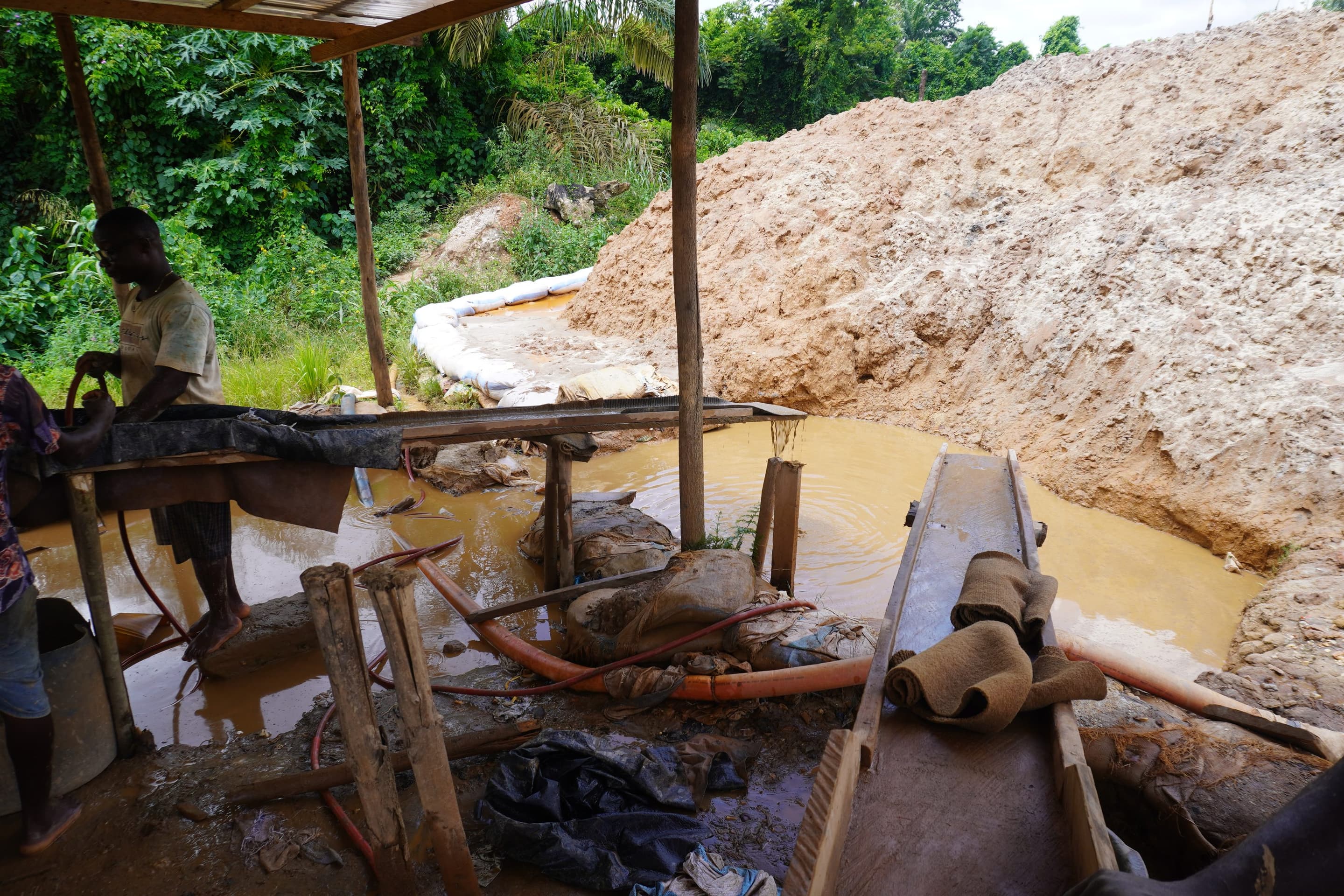 An active galamsey site in the Western North Region: pumps, spoil heaps and silted water where forest used to stand